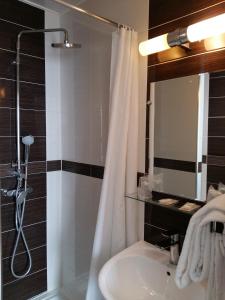 y baño con ducha y lavamanos. en Hôtel Roi René, en París