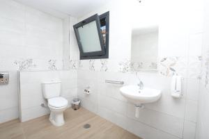 a white bathroom with a toilet and a sink at H.PALMONES in Palmones