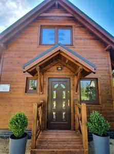a log cabin with a front door and twoiaries at Stepnicka Keja in Stepnica