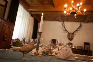 une table avec une bougie et un oiseau sur une table dans l'établissement Kormos Residence, à Brăduţ