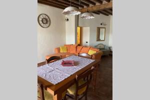 a dining room with a table and a couch at La Casina in Asciano
