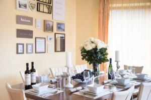 a dining room table with a vase of flowers and wine bottles at Charming Villa in a Private Mountain Resort in Braşov