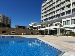 a large swimming pool in front of a building at Verdi Santarém in Santarém