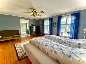 Un dormitorio con una cama y un ventilador de techo. en Villa Edvin - Slow living, en Eide