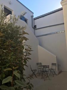 a group of chairs and a plant next to a building at L îlot Grec in Saint-Palais-sur-Mer