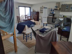 a living room with a couch and tables and chairs at L îlot Grec in Saint-Palais-sur-Mer