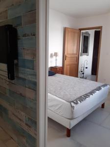 a bedroom with a bed and a brick wall at L îlot Grec in Saint-Palais-sur-Mer