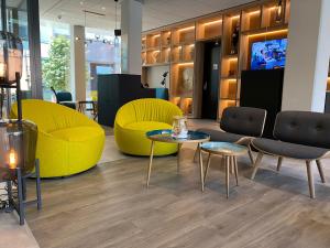 a store with yellow chairs and tables and chairs at ibis budget Lugano Paradiso in Lugano
