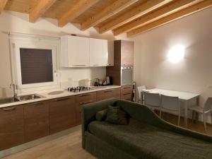 ein Wohnzimmer mit Sofa und eine Küche in der Unterkunft Villacolle Visso in Visso
