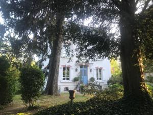 uma casa branca com uma porta azul e árvores em Le Clos des Princes em Châtenay-Malabry