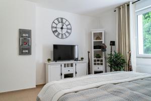 1 dormitorio con 1 cama y reloj en la pared en Beautiful Apartment in town centre (TLA/TDY/TLF) en Landstuhl