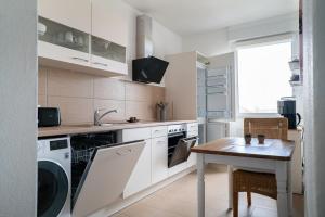 a kitchen with a washing machine and a table at Beautiful Apartment in town centre (TLA/TDY/TLF) in Landstuhl