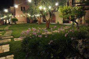 - un jardin avec des fleurs et des lumières la nuit dans l'établissement Villa Rosa Antico Dimora Storica, à Otrante