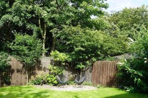 zwei Stühle in einem Garten neben einem Zaun in der Unterkunft The Pavilion - Stunning, 4 Bedroom House with Free Parking in Wakefield