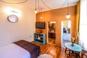 1 dormitorio con 1 cama y reloj en la pared en ATRIUM 24 Suite, en Sighişoara
