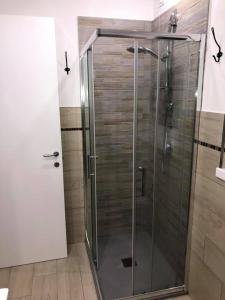 La salle de bains est pourvue d'une douche avec une porte en verre. dans l'établissement Rosa dei Venti B&B, à Petacciato