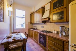 een keuken met houten kasten, een tafel en een fornuis bij Vie d'acqua Aposa - City Center- BO in Bologna