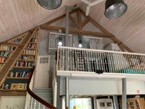 um loft com uma escada e estantes num quarto em B&B De Lage Zwaluw em Lage Zwaluwe