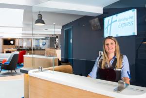 a woman sitting at a counter in an office at Holiday Inn Express Swindon City Centre, an IHG Hotel in Swindon