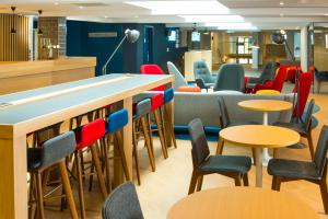 una sala de espera con mesas y sillas en Holiday Inn Express Swindon City Centre by IHG, en Swindon
