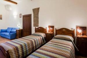 een slaapkamer met 2 bedden en een blauwe stoel bij Vie d'acqua Aposa - City Center- BO in Bologna