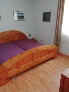 Una cama hecha de un marco de madera en un dormitorio en Wershofen/Eifel, en Wershofen