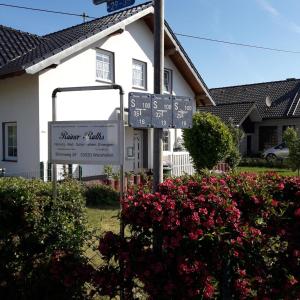 a street sign in front of a house with flowers at Wershofen/Eifel in Wershofen