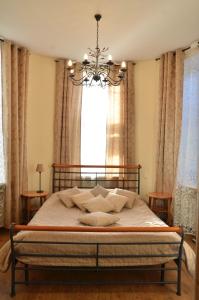 a bedroom with a bed with a chandelier and a window at Best Corner in Saint Petersburg