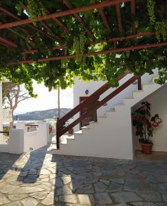 a staircase leading up to a house with green vines at Sofirene Sea View in Batsi