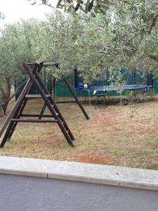 a swing set in a park with a table at Villa Arancia in Peruški