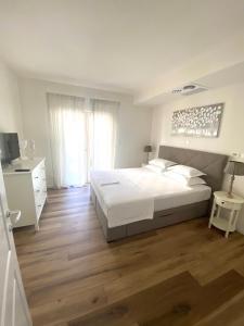 ein Schlafzimmer mit einem großen weißen Bett und Holzböden in der Unterkunft Baltimore.House in Baška Voda + 84 Fotos