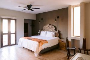 1 dormitorio con 1 cama grande y ventilador de techo en Casa Naré Adults Only en San Miguel de Allende