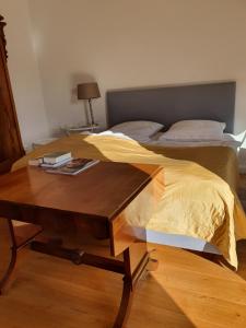 - un lit avec une table en bois et une couverture jaune dans l'établissement Großzügige,98m2 grosse Wohnung in stadtnaher Traumlage, nur 200m zum Stadtpark, à Oldenbourg