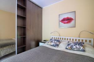 1 dormitorio con cama y espejo en Apartament Bursztyn 2, en Świnoujście