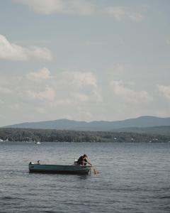 un hombre está remando un bote en el agua en Domaine Jolivent, en Lac-Brome