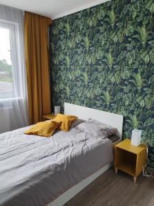 sypialnia z łóżkiem i zieloną ścianą w obiekcie Noclegi Róża Wiatrów w mieście Górowo Iławeckie
