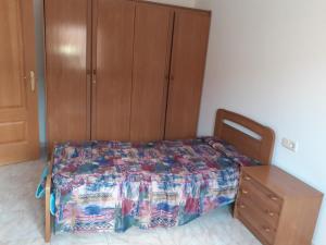 Schlafzimmer mit einem Bett und einem Holzschrank in der Unterkunft Casa URIN in Almenar