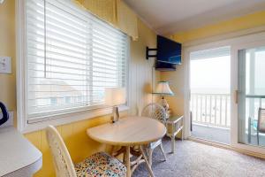 a dining room with a table and chairs and a window at Beachfront Blessing in Myrtle Beach