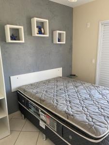 a large bed in a bedroom with two shelves at Apto Frente ao Mar in Bertioga