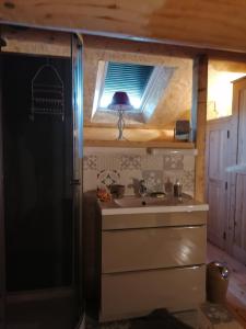 a bathroom in a tiny house with a sink and a window at Mas Ribou in Barbentane
