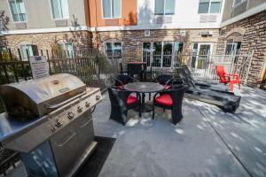 a patio with a grill and a table and chairs at Holiday Inn Express Hotel & Suites Ontario, an IHG Hotel in Ontario