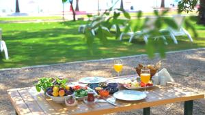 a picnic table with food and two glasses of orange juice at Dolunay Suit & Beach in Muğla
