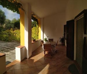 un patio con mesa y sillas en una casa en Idillio Mediterraneo, en Magomadas