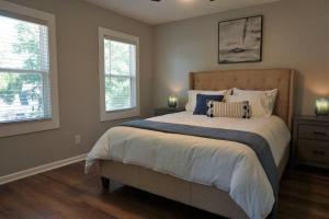 a bedroom with a large bed and two windows at Beautiful & large newly renovated 5 bedroom house. in Marietta