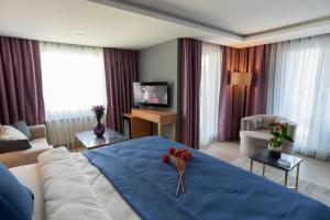a bedroom with a large bed and a living room at Malta Bosphorus Hotel in Istanbul
