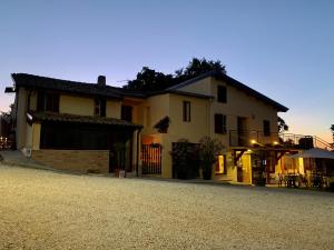 une maison assise sur une route en gravier devant dans l'établissement Chiaraluce Country House, à Massignano