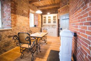 a kitchen with a table and chairs in a brick wall at Pajusi Mõisa Külalistemaja in Põltsamaa