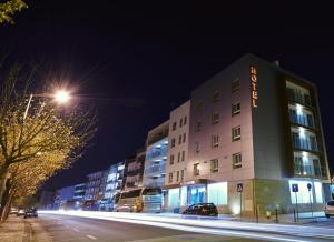 a building with a sign on it at night at Hotel Azinheira in Fátima