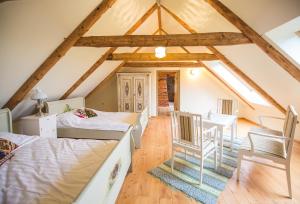 a attic bedroom with two beds and a table and chairs at Pajusi Mõisa Külalistemaja in Põltsamaa