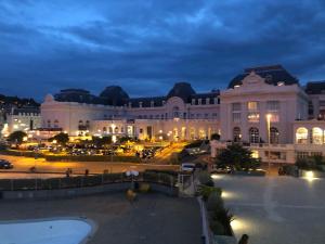 a large building at night with a parking lot at SON DES MOUETTES PLAGE in Trouville-sur-Mer
